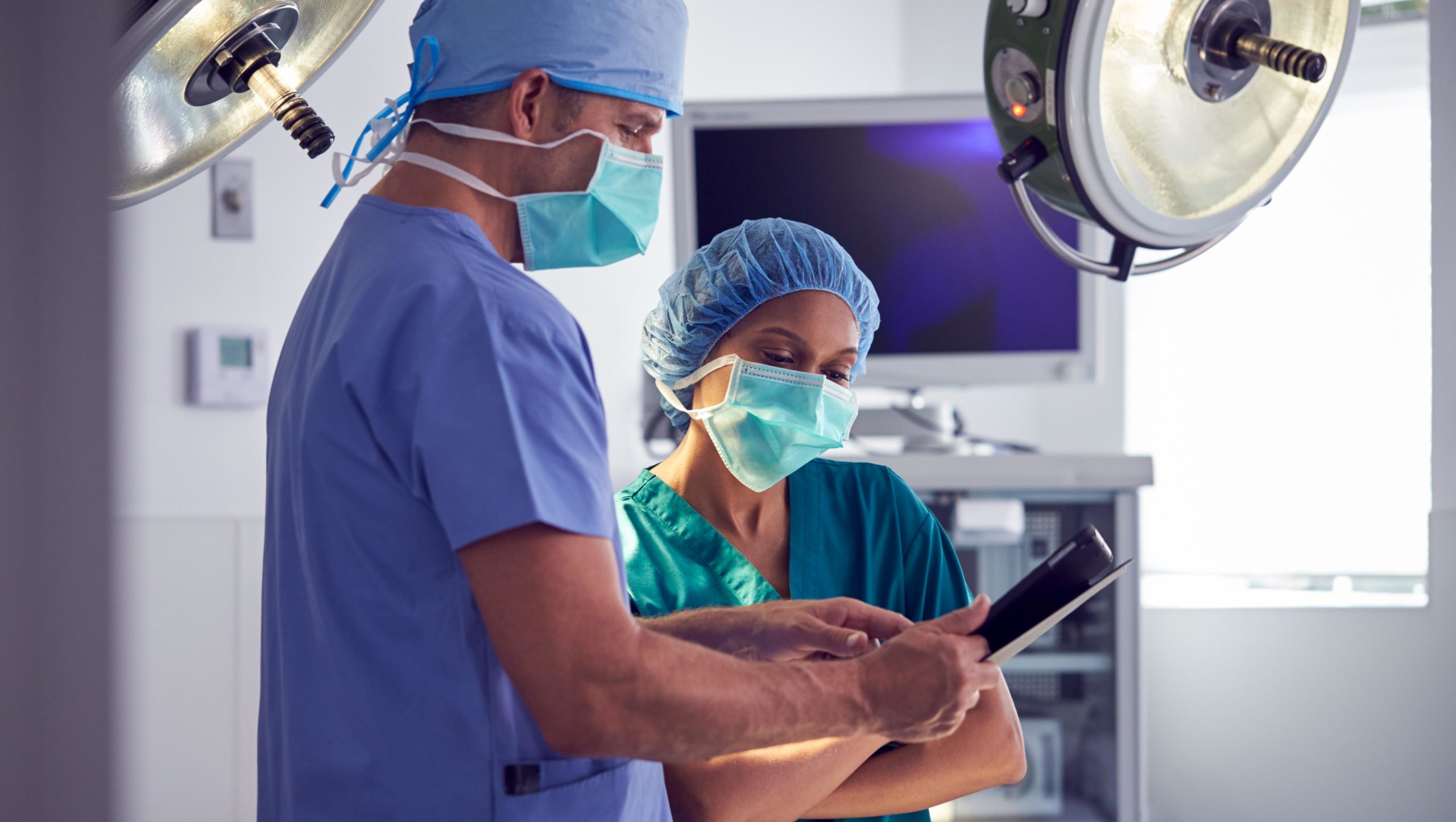 Surgeons wearing scrubs looking at medical records